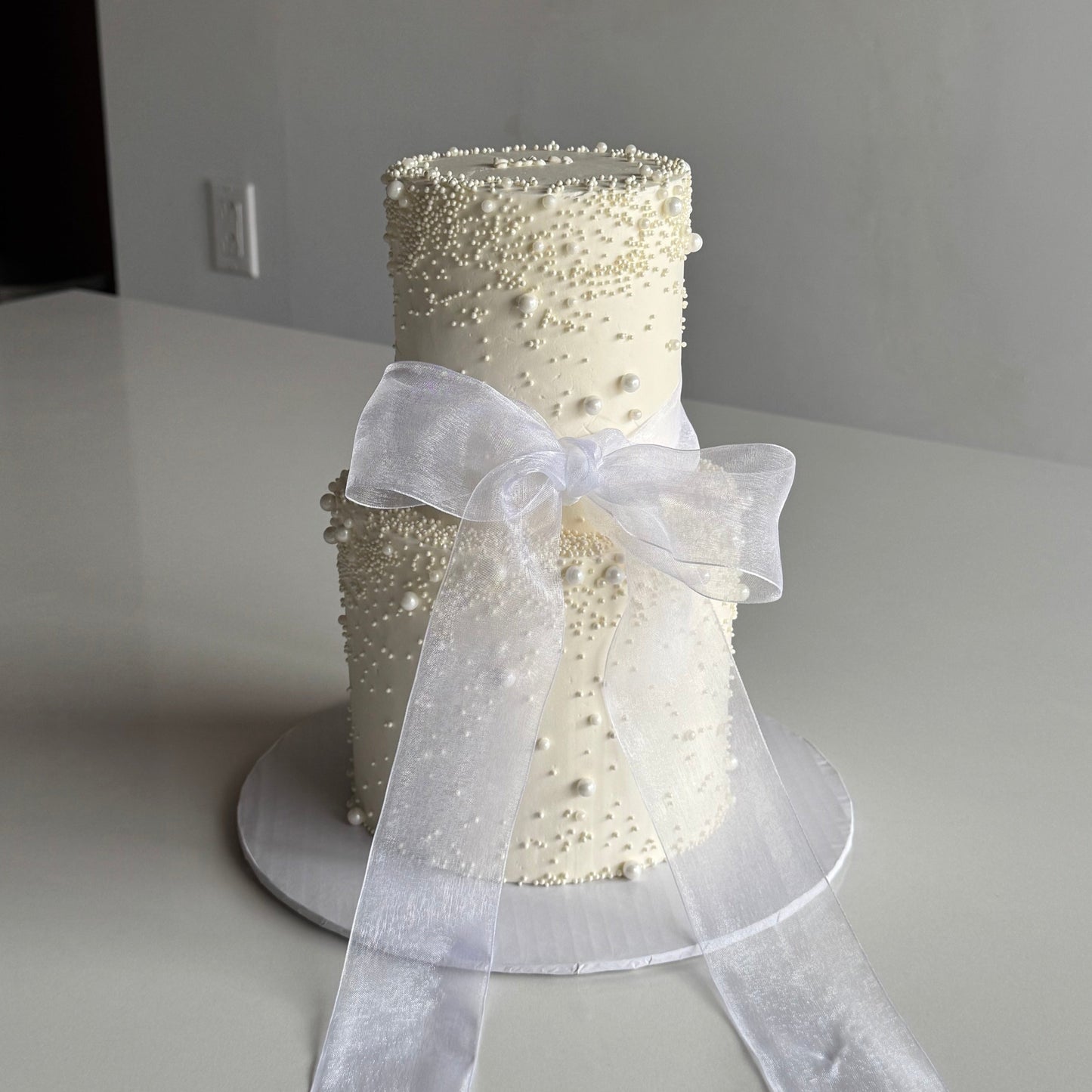 2 tier wedding cake with thick mesh bow and pearl design for a wedding in Montreal