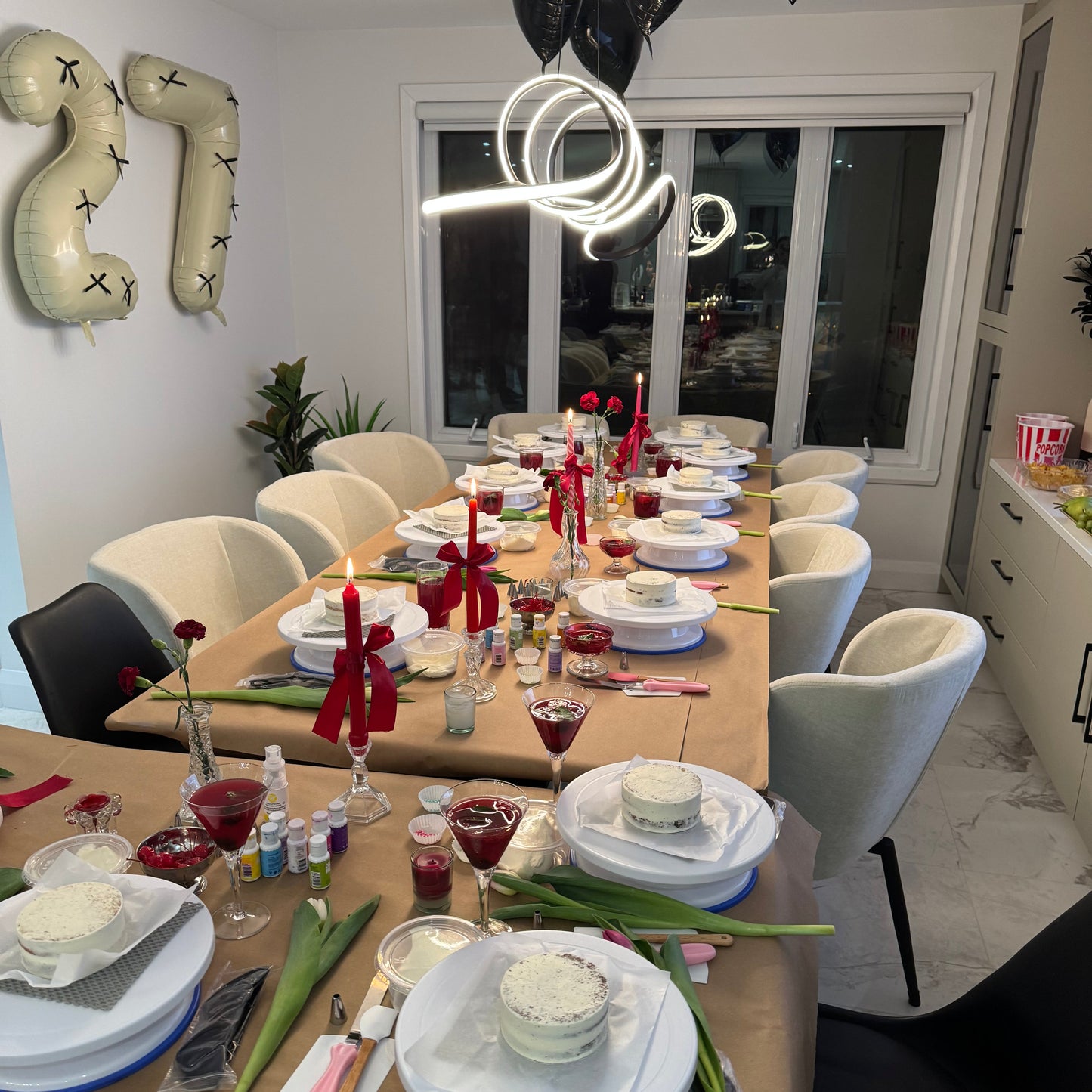 Table set up with turntables, cakes, drinks, supplies, decor for a private cake decorating class in Montreal