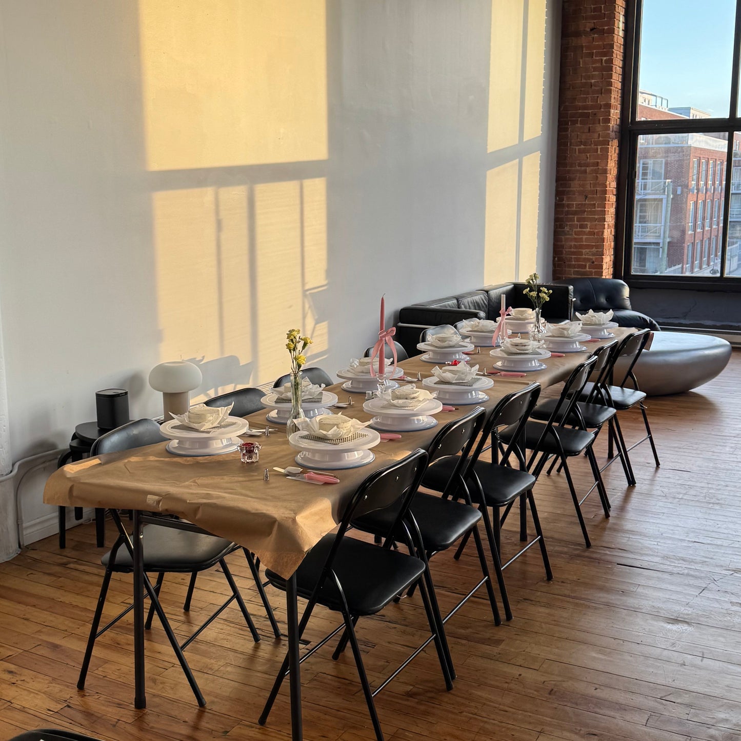 Table set up with turntables, cakes, supplies, and decor for a cake decorating class in Montreal