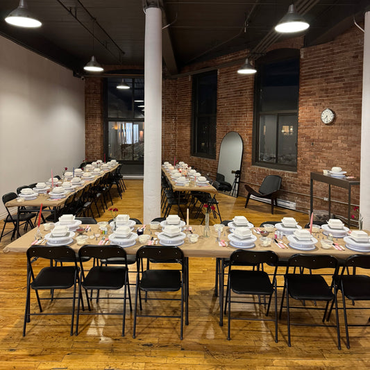Table set up with turntables, cakes, supplies and decor for a cake decorating class in Montreal
