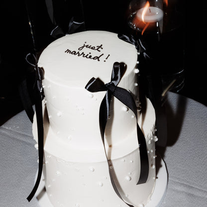 2 tier pearl wedding cake with minimal piping, pearls, and bows for a wedding in Montreal