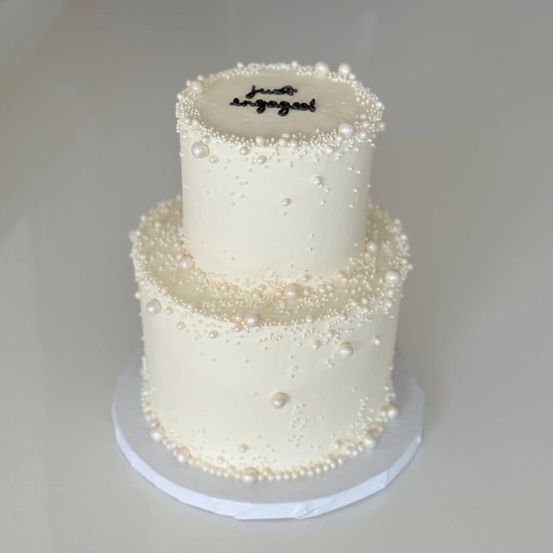 2 tier pearl wedding cake with minimal piping and pearls for a wedding in Montreal