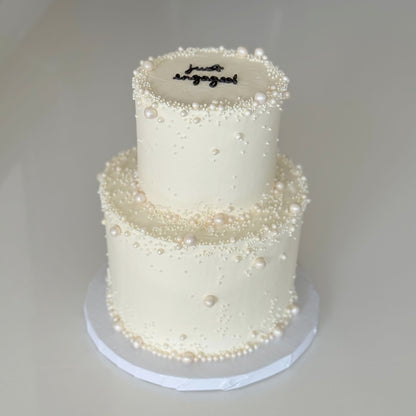 2 tier pearl wedding cake with minimal piping and pearls for a wedding in Montreal